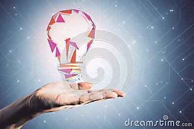 Hand hoding glowing polygonal lamp Stock Photo