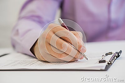 The hand hold a black pen on note book and data reported papers Stock Photo