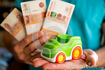 Hand hold green toy car and russian money.fixed rate for car loan, or Saving money for car, trade car for cash, finance Stock Photo