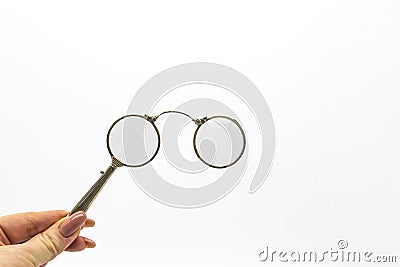 Hand hold an old vintage lorgnette from the middle of the nineteenth century on the white background Stock Photo