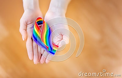 Hand hold a rainbow of LGBT tapes on a LIGHT background. Copy space The concept of homosexuals and LGBT people. Stock Photo