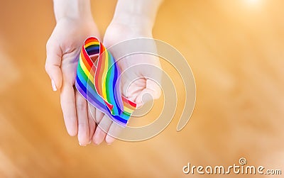 Hand hold a rainbow of LGBT tapes on a LIGHT background. Copy space The concept of homosexuals and LGBT people. Stock Photo