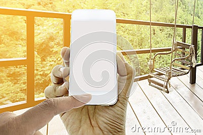 Hand hold and touch screen smart phone on rusty iron seat swing Stock Photo