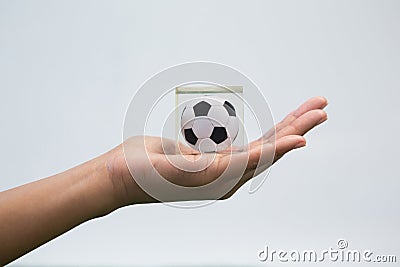 Hand holding acrylic football cube against white background Stock Photo