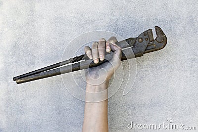 Hand holding a adjustable wrench isolated on gray background. Stock Photo