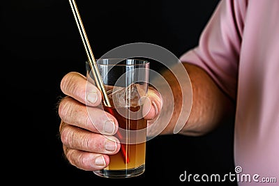 hand holding arnold palmer with a chilled metal straw Stock Photo
