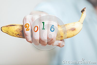 Hand holding banana. On fingers number of year Stock Photo