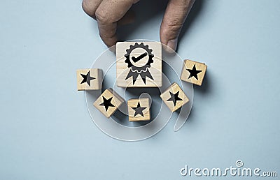 Hand holding the best quality assurance with golden five stars for guarantee product and ISO service concept Stock Photo