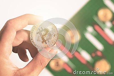 Hand holding bitcoin with background Candlestick chart make from color paper white and red Editorial Stock Photo