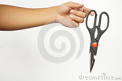 Hand holding a black scissor. Closed, not ready to cut position. White background Stock Photo