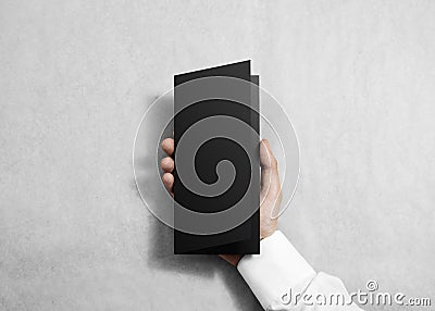 Hand holding blank black opened brochure booklet. Stock Photo