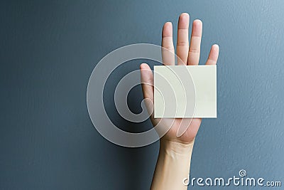 Hand holding blank card, representing the anonymity of a plagiarist, gray background Stock Photo