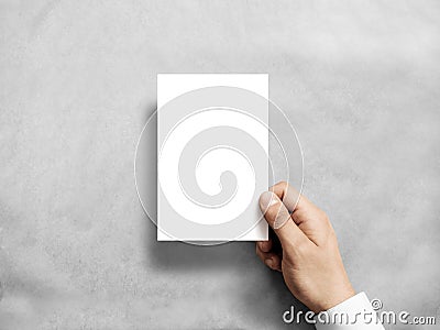 Hand holding blank white vertical postcard flyer mockup. Stock Photo