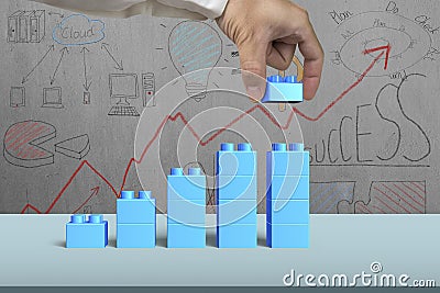 Hand holding blue block complete growth bar graph shape Stock Photo