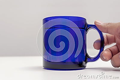 Hand holding a blue cup of tea Stock Photo