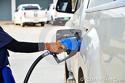 Hand holding the blue diesel nozzle At the gas station, the concept of oil crisis, expensive oil Stock Photo
