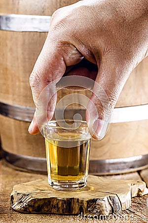 male hand holding a glass of distilled alcoholic beverage, called pinga or cachaça. Stock Photo