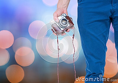 Hand holding camera with sparkling light bokeh background Stock Photo
