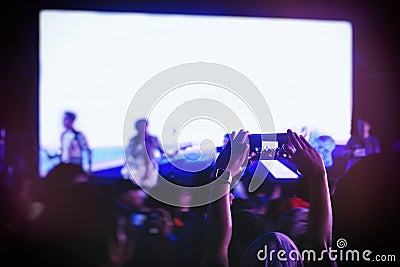 Hand holding Cell phone Blank screen Photo shot Blur Concert Background Stock Photo