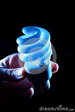 Hand holding cfl blue light-bulb lamp Stock Photo