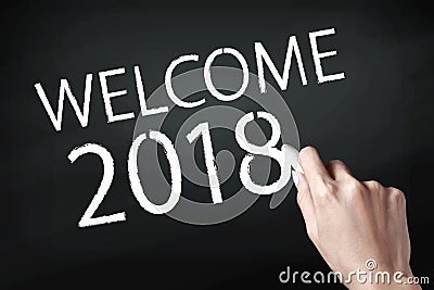 Hand holding a chalk and writing welcome 2018 Stock Photo