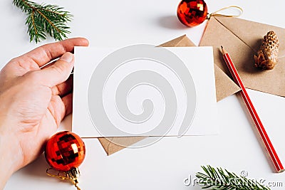 Hand holding Christmas blank greeting card mock-up for invitation or wish, close-up. Happy new year composition template Stock Photo