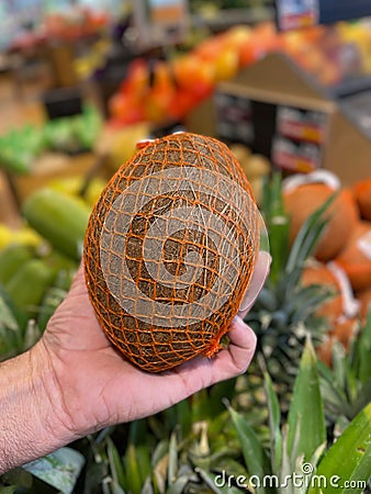 Hand holding a coconut grocery store produce background Stock Photo