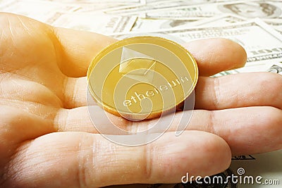 Hand holding coin ethereum ETH under dollar banknotes. Cryptocurrency mining. Editorial Stock Photo