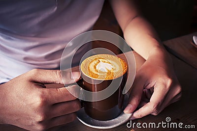 hand holding cup of coffee top view surface heart shape in wooden background Stock Photo