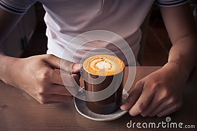 hand holding a cup of coffee top view surface heart shape in wooden background Stock Photo