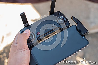 Hand holding drone remote controler to operate flying drone Stock Photo