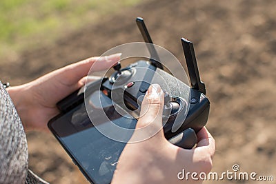 Hand holding drone remote controler to operate flying drone Stock Photo