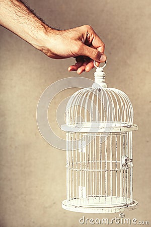 Hand holding an empty cage. Absence of ideas and dreams. Freedom and hope. Stock Photo