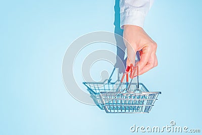 hand holding empty metal shopping basket. Stock Photo