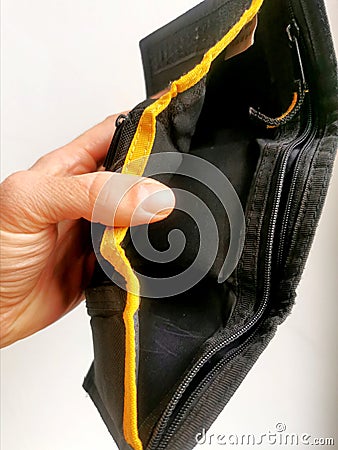 Hand holding an empty wallet with no money left inside Stock Photo