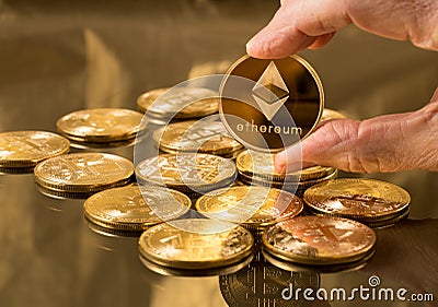 Hand holding ether coin over bitcoins Editorial Stock Photo