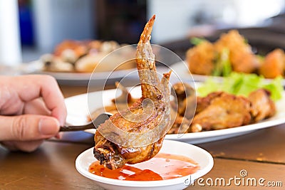 Hand holding Fork stabbing Fried Chicken Stock Photo