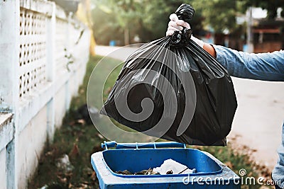 hand holding garbage black bag putting in to trash Stock Photo