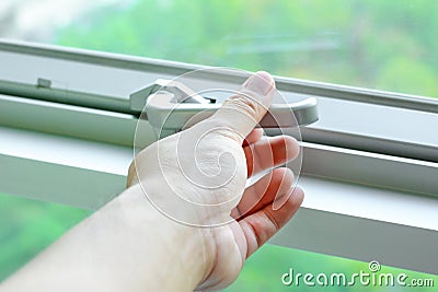 Hand holding glass window latch lever Stock Photo