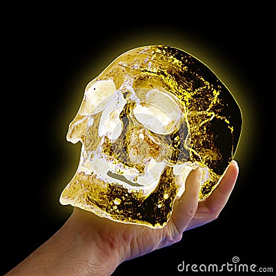 A hand holding a glowing human skull on a black background Stock Photo