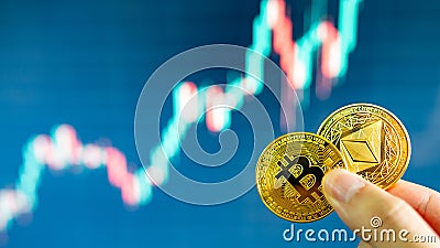 Hand holding gold Bitcoin and Ethereum Editorial Stock Photo