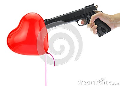 Hand holding at gunpoint a heart balloon Stock Photo