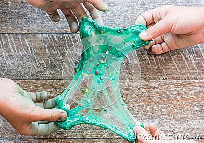 Hand holding homemade green slime with tinsel Stock Photo