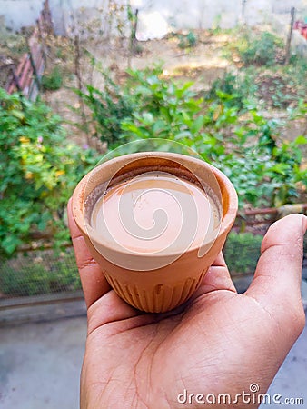 Hand holding Hot Indian spiced tea served in a traditional clay pot glass called Kulhad. Uttarakhand , India Stock Photo