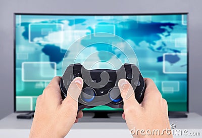 Hand holding joystick to playing video game on tv Stock Photo