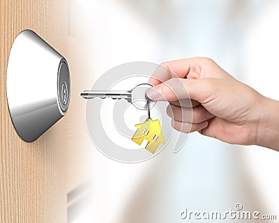 Hand holding key with house shape key-ring to unlock Stock Photo
