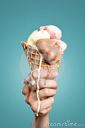 Melting ice cream cone held in hand Stock Photo