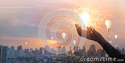 Hand holding light bulb and brain and network connection on city background, Idea and imagination, Creative and inspiration. Stock Photo