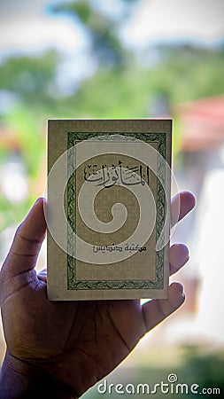 Hand holding a mini book written Al-Mathurat in Arabic word Editorial Stock Photo