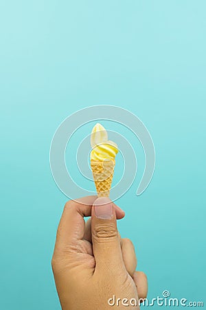 Hand holding a mini vanilla soft ice cream in wafer cone Stock Photo